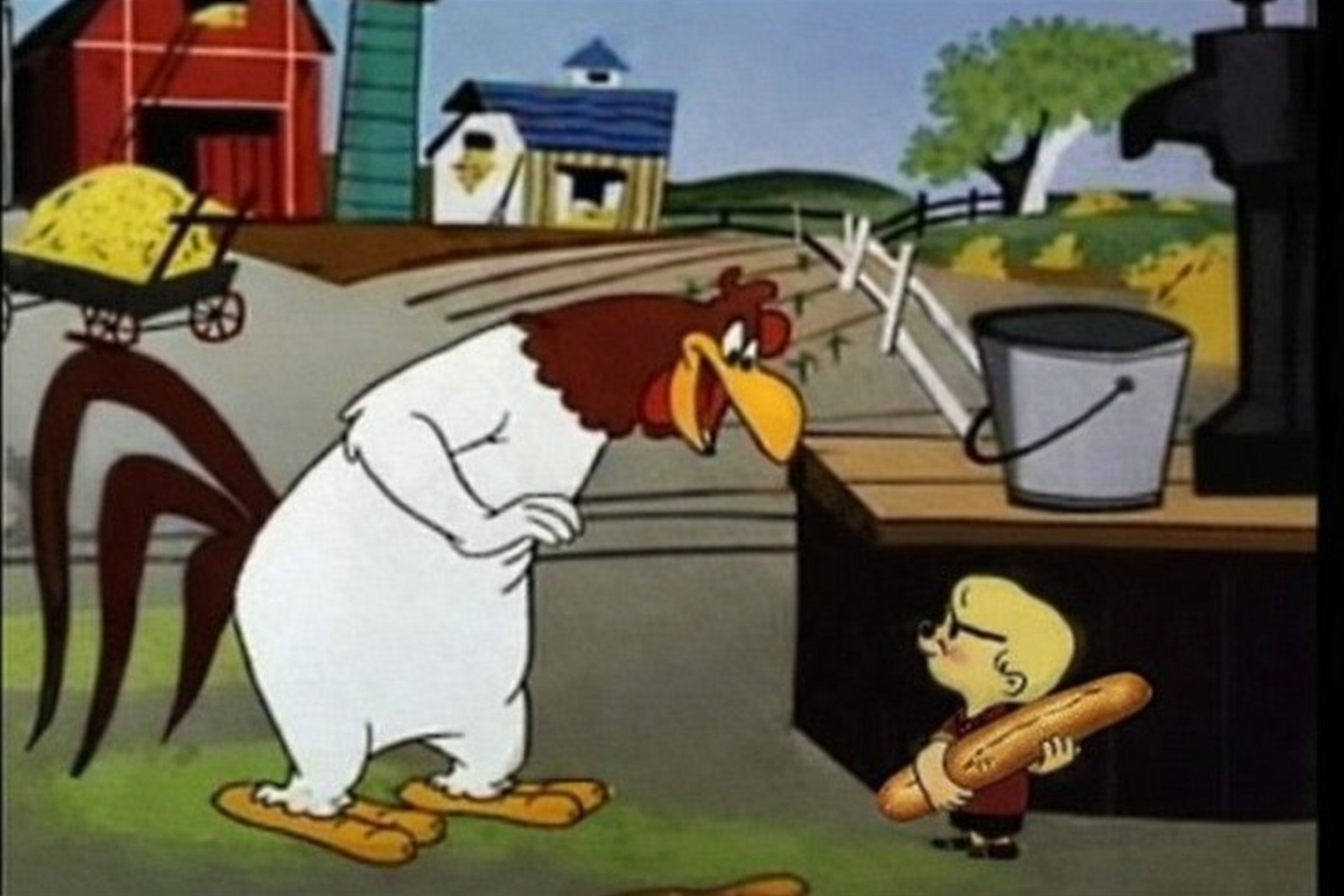 El Gallo Claudio con el pollito sabihondo que trae una barra de pan bajo el ala