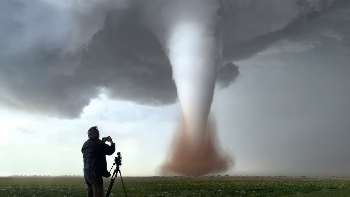 Un hombre fotografiando un tornado 
